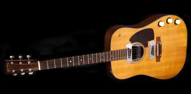 Acoustic guitar with three knobs, a pickup, and a dark tortoiseshell pickguard